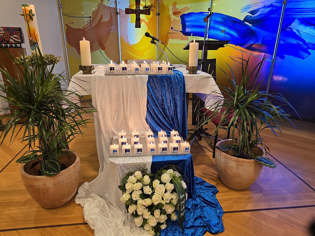 Dekorierter Altar mit Kerzen, Blumen und Pflanzen in einem stilvollen Arrangement.