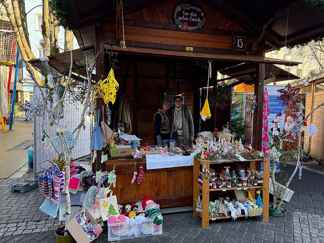 Holzhütte mit Verkaufsstand, dekoriert mit Weihnachtsartikeln und handgemachten Geschenken.