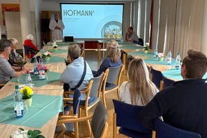 Besprechung mit Teilnehmern in einem Konferenzraum, Präsentation auf Leinwand